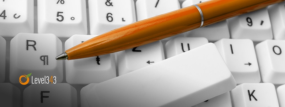 a pen on a computer; preparing to write headlines