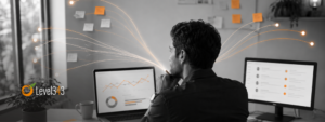 Realistic black-and-white image of a marketer reviewing dashboards and notes at a desk, with orange signal lines connecting data points, sticky notes, and reports to show the process of interpreting marketing signals.