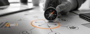 A hand uses a compass to find direction on a strategy diagram, with an orange circle highlighting the central decision point.