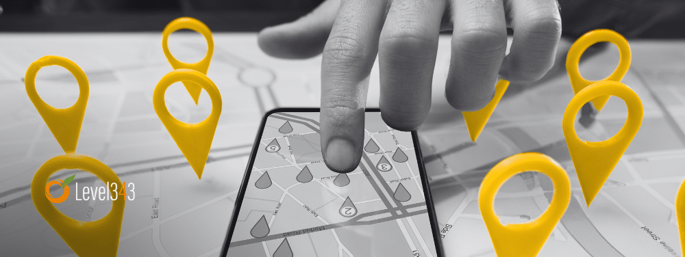 hand pointing a map on a mobile phone, with map pins surrounding the hand. Local SEO concept