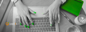 woman's hands typing on a laptop as she writes a blog