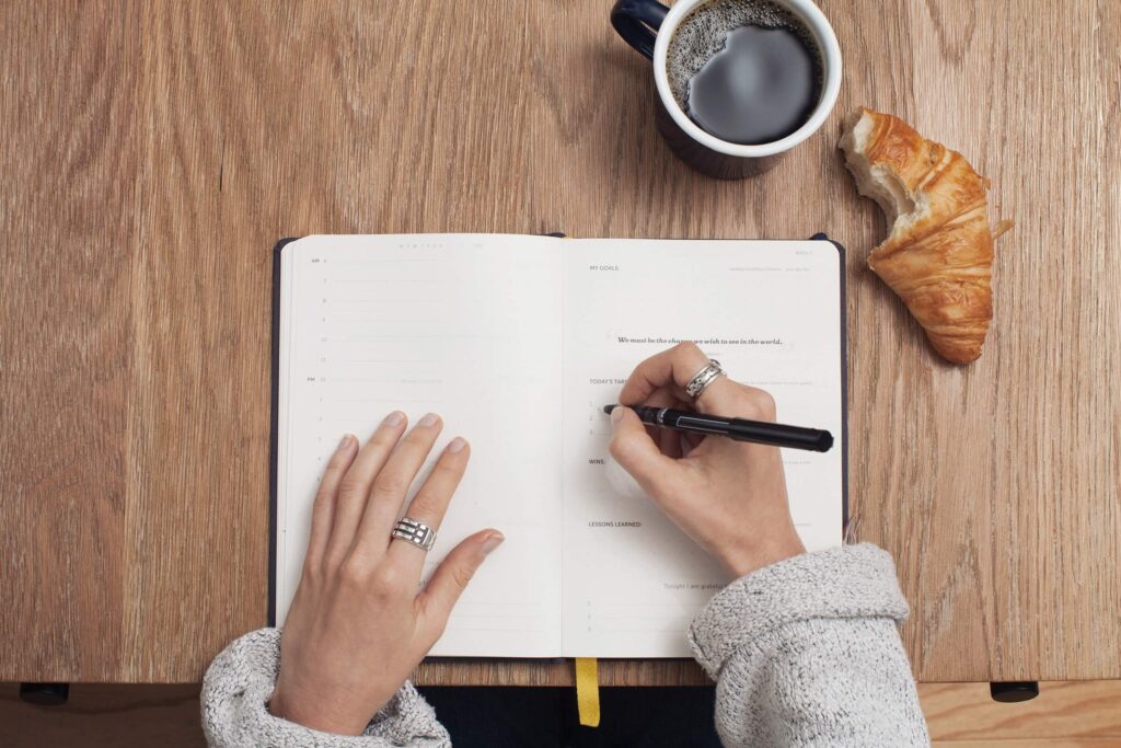 person writing on a notebook